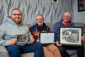 SGB 2823 left to right Robert Keith and Roy Coulson holding pictures of previous Coulson employees at Forterra